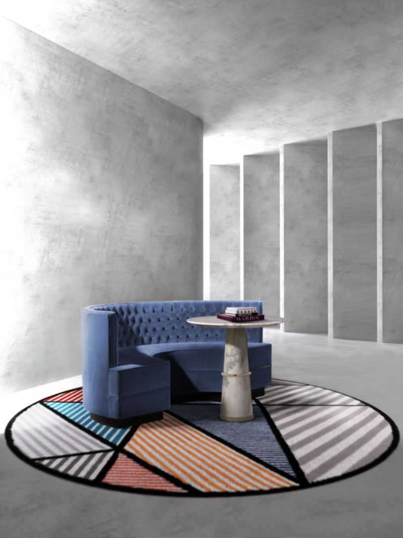 minimalist midcentury reading corner with round LOLA RUG with a lot of colors paired with the blue bourbon curved sofa. Why Modern Wool Rugs Are The Best For A Reading Corner Interior Design