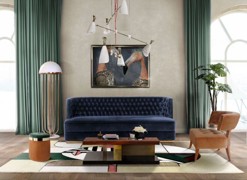 modern contemporary living room with the abstract rug named Oscar Rug. There is a blue velvet sofa with light brown orange amrchair and a wooden center table.