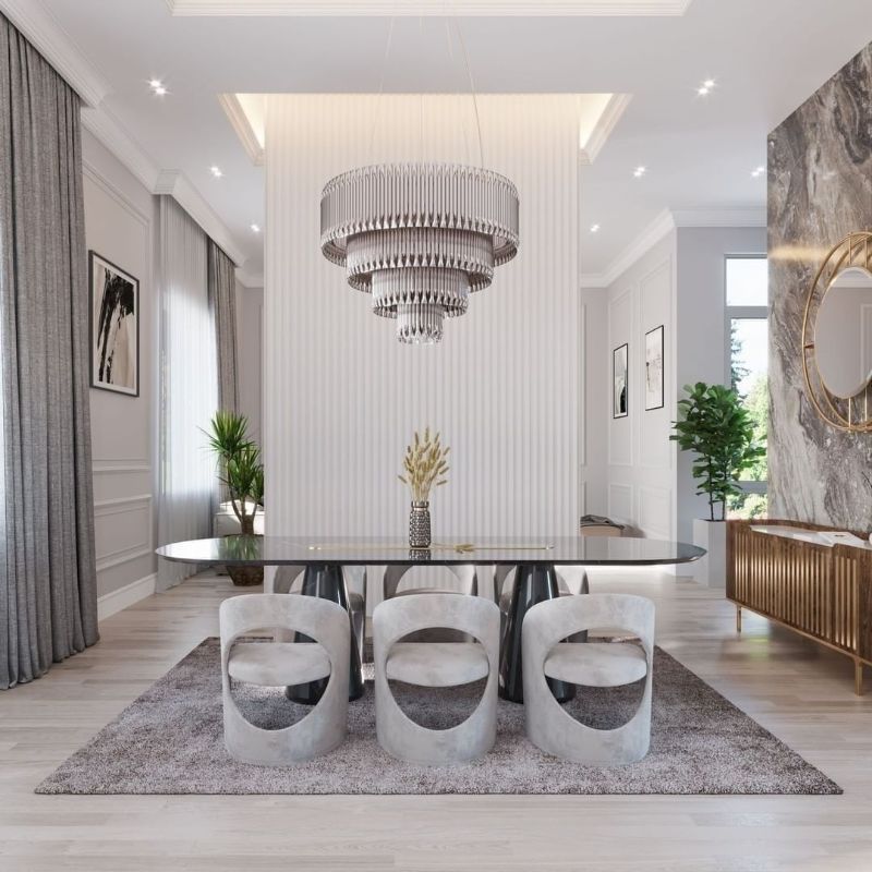 gray dining room with area rug and round shaped dining chairs with silver chandelier and oval black dining table