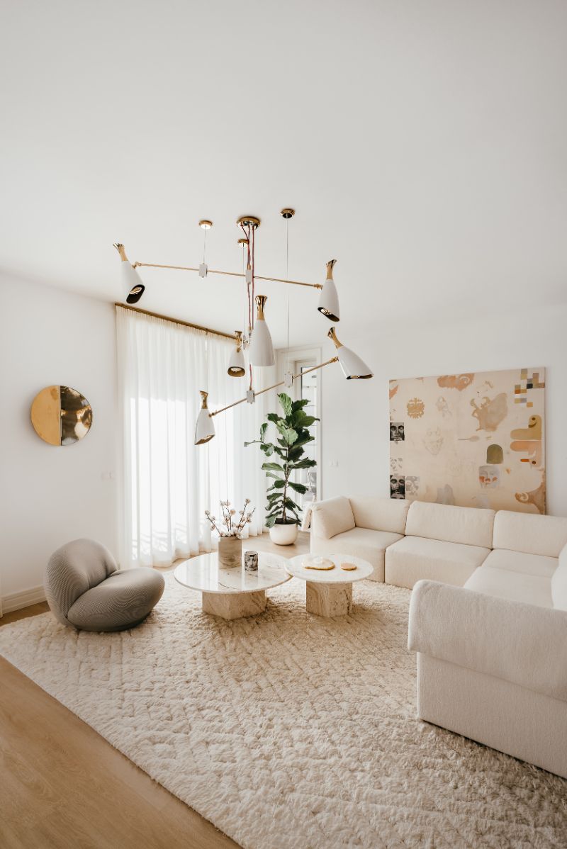 white living room with area rug, center table and hanging lights