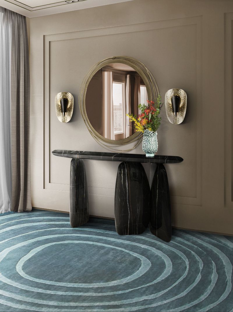 Modern contemporary hallway with blue EYE RYG and black console with round mirror in gold. Colorful Contemporary Rugs To Brighten Your Hallway