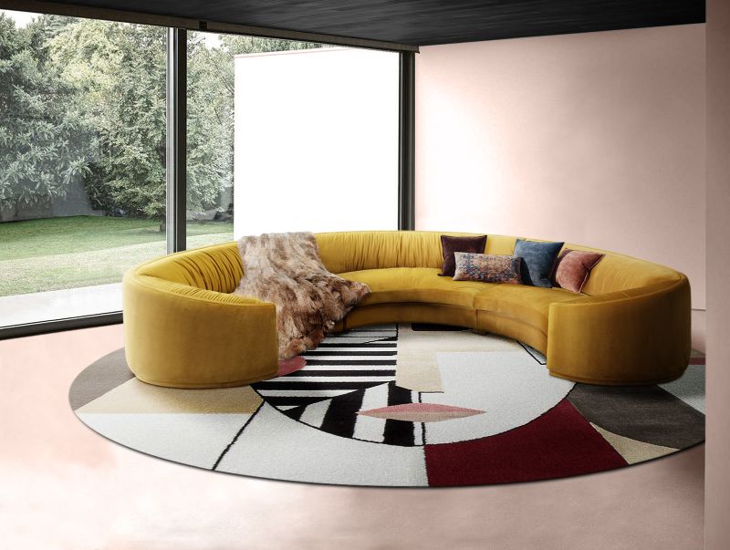 modern contemporary living room with round rug with geometric shapes that create a human figure, with orange couch. Rug Mistakes To Avoid When Redesigning your Interior With Modern Rugs