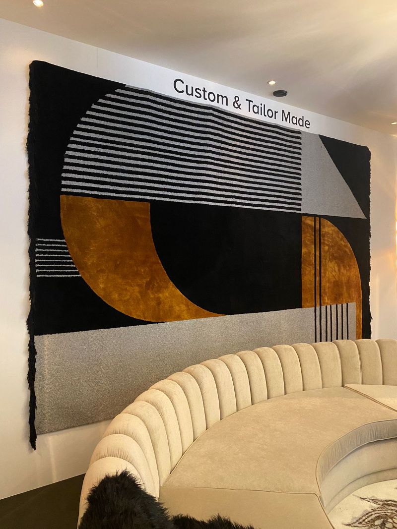 Where To Find The Finest Luxury Rugs at iSaloni 2022 -  a geometric wall rug with black, orange and gray hues
