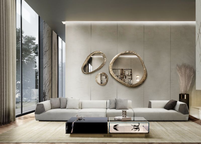 luxury elegant living room with a large beige area rug with a white sofa and round mirror in brass.